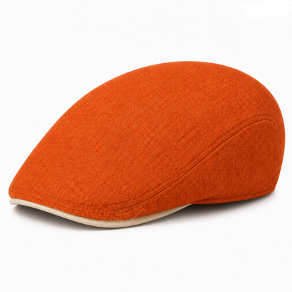 A bright orange wool flat cap with a contrasting cream-colored brim, photographed on a clean white background.