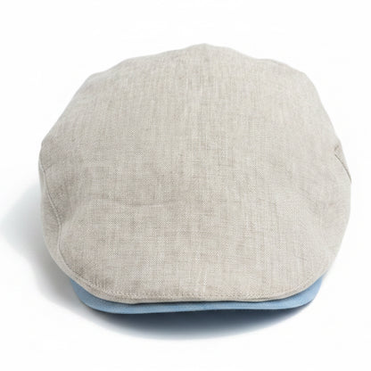 A light beige linen flat cap with a light blue underside, photographed from the front on a white background 