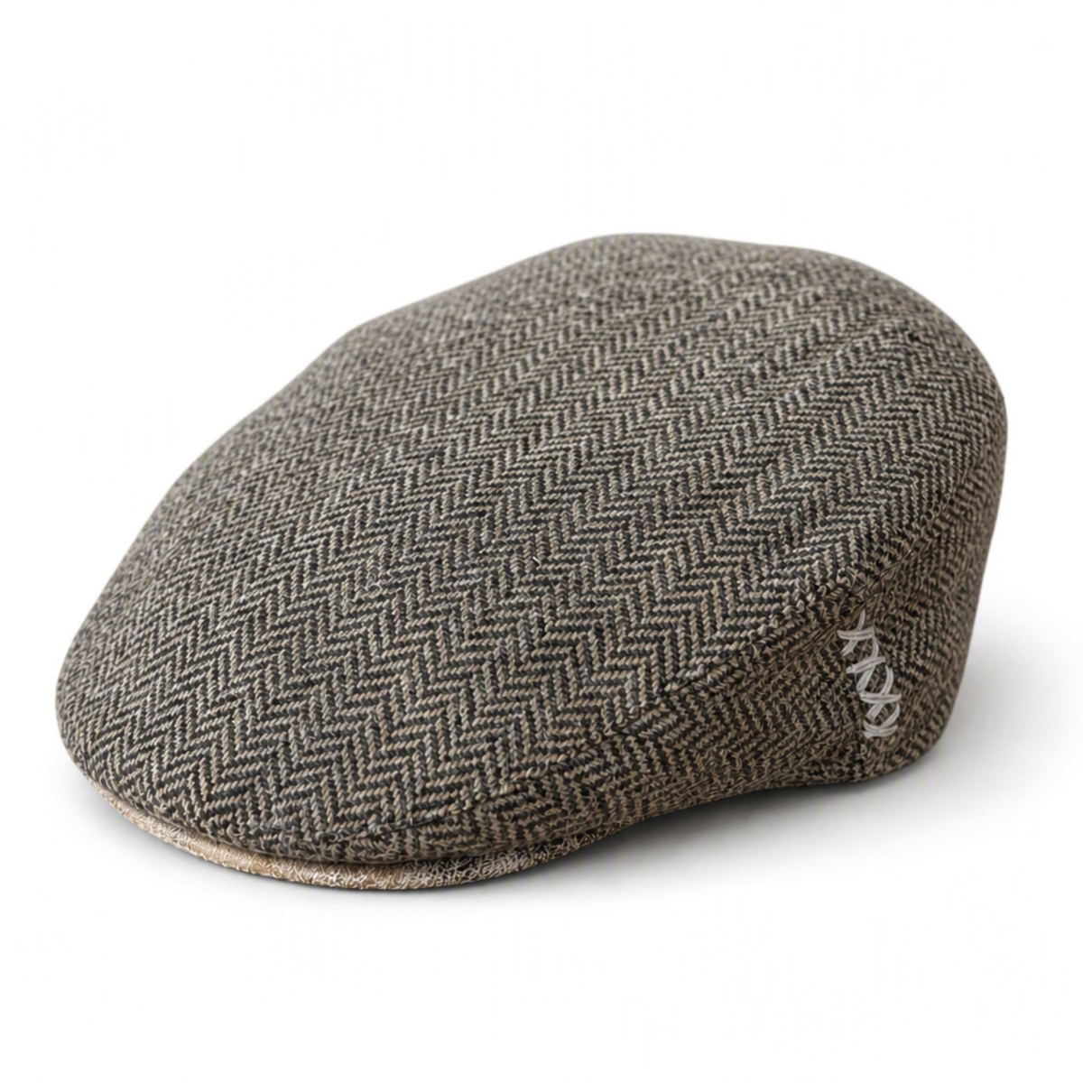 Brown herringbone flat cap with cream colored ‘x’ stitches on the side and a distressed cream suede brim on a solid white background 